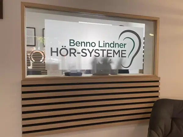 Schaufenster mit Logo von Benno Lindner Hörsysteme und stilisiertem Ohr im Geschäft.